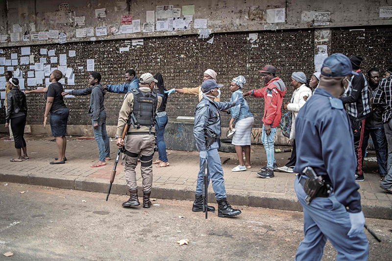 Mail and Guardian Piece on KRISP Keep it safe: Police enforce social distancing between people outside a supermarket in Yeoville, Johannesburg